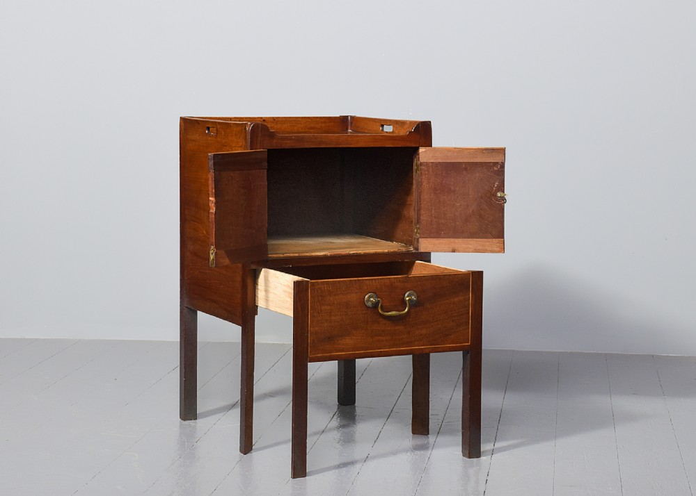 A George III mahogany bedside commode featuring a gallery tray top with cut-out handles, twin flame-mahogany doors, and a single lower drawer on square legs. View VII