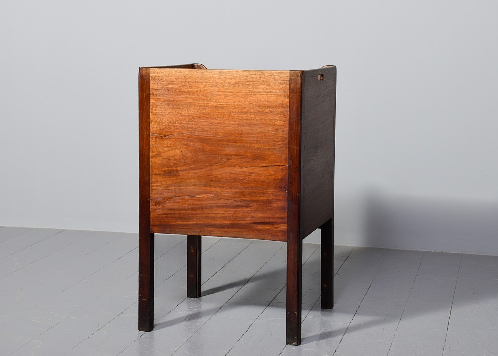 A George III mahogany bedside commode featuring a gallery tray top with cut-out handles, twin flame-mahogany doors, and a single lower drawer on square legs. View VIII