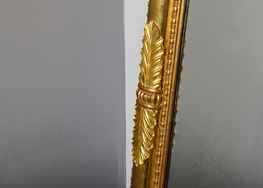 A tall Regency gilded pier mirror featuring a carved architectural cornice, side columns with leaf motifs, and a central classical frieze. View III