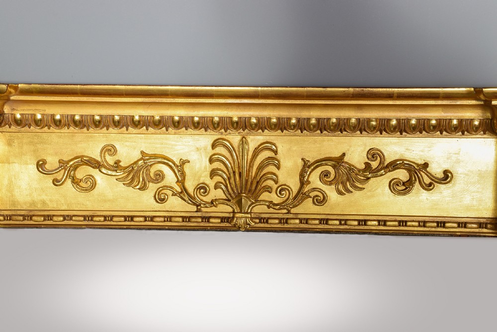 A tall Regency gilded pier mirror featuring a carved architectural cornice, side columns with leaf motifs, and a central classical frieze. View IV