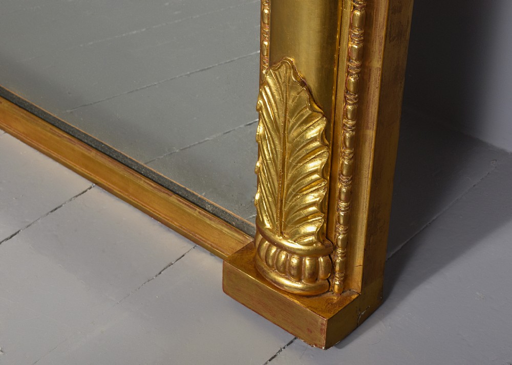 A tall Regency gilded pier mirror featuring a carved architectural cornice, side columns with leaf motifs, and a central classical frieze. View V