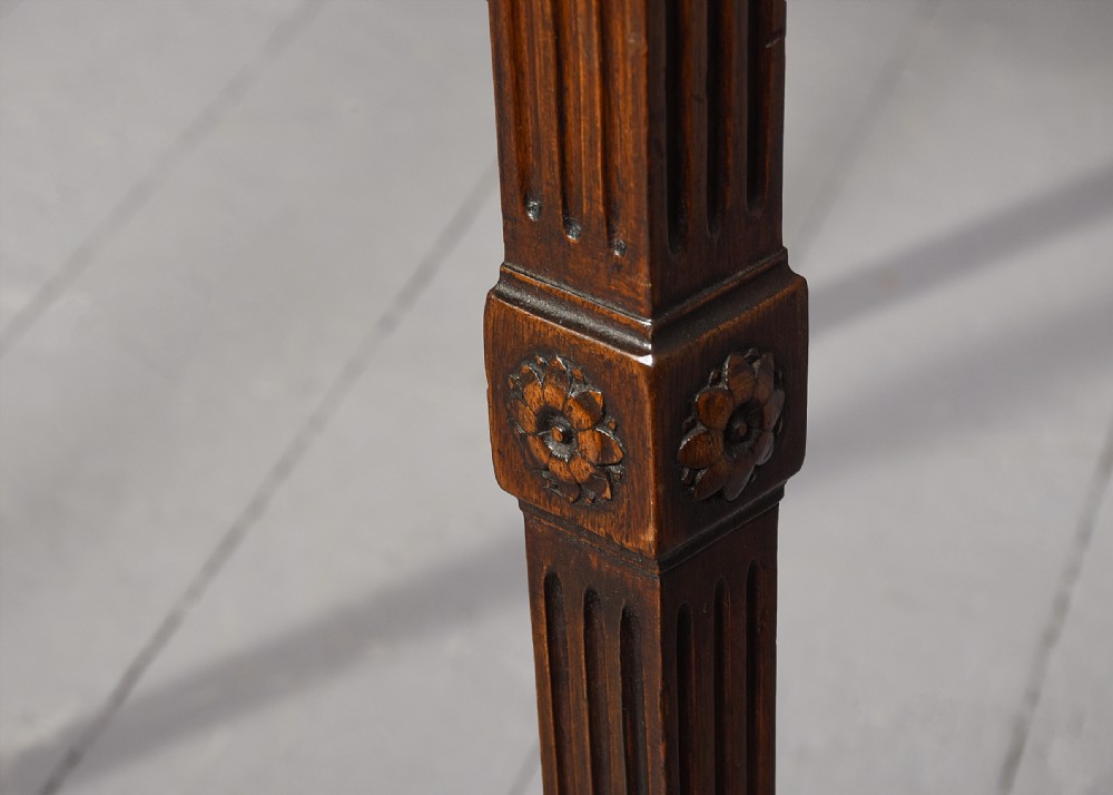 A long Georgian mahogany console table featuring a carved frieze with urn motifs and swags, brass ring handles, and fluted legs. View III