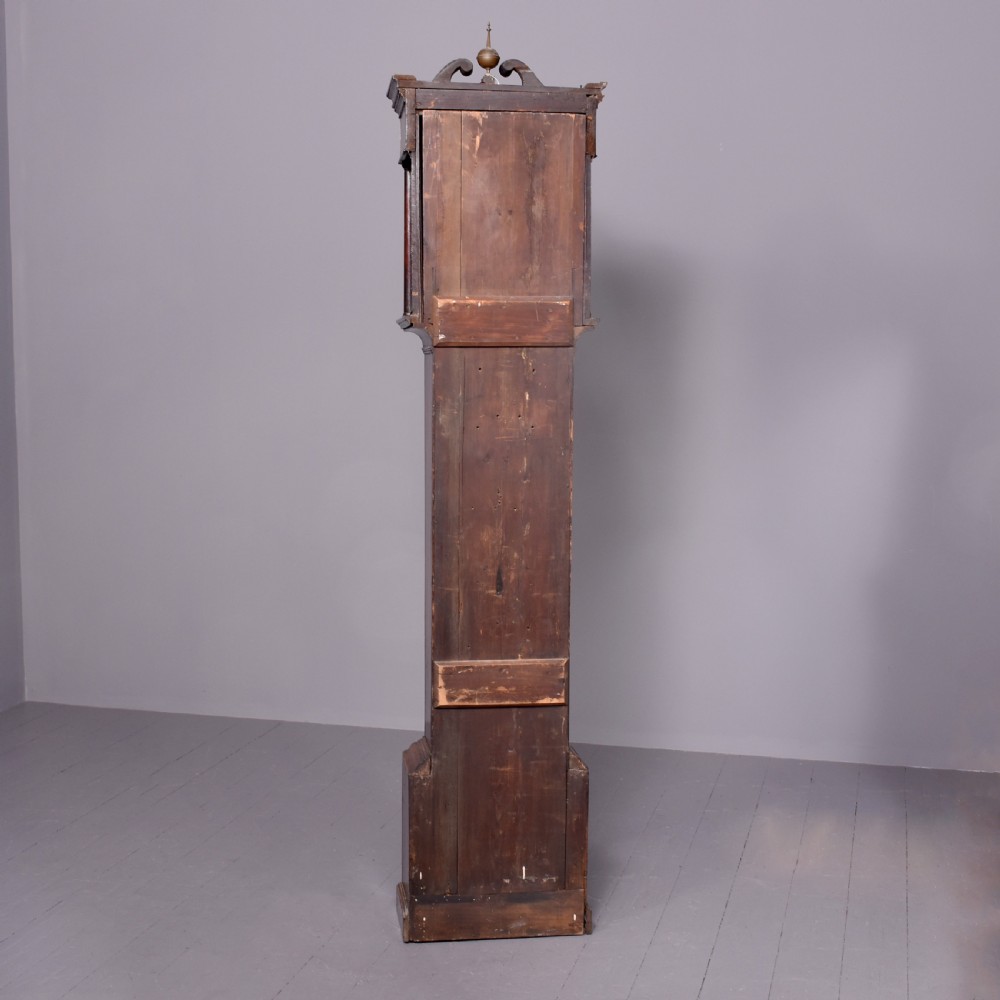 A George III dark mahogany longcase grandfather clock featuring a swan-neck pediment, brass finial, and an engraved brass arch dial. View II