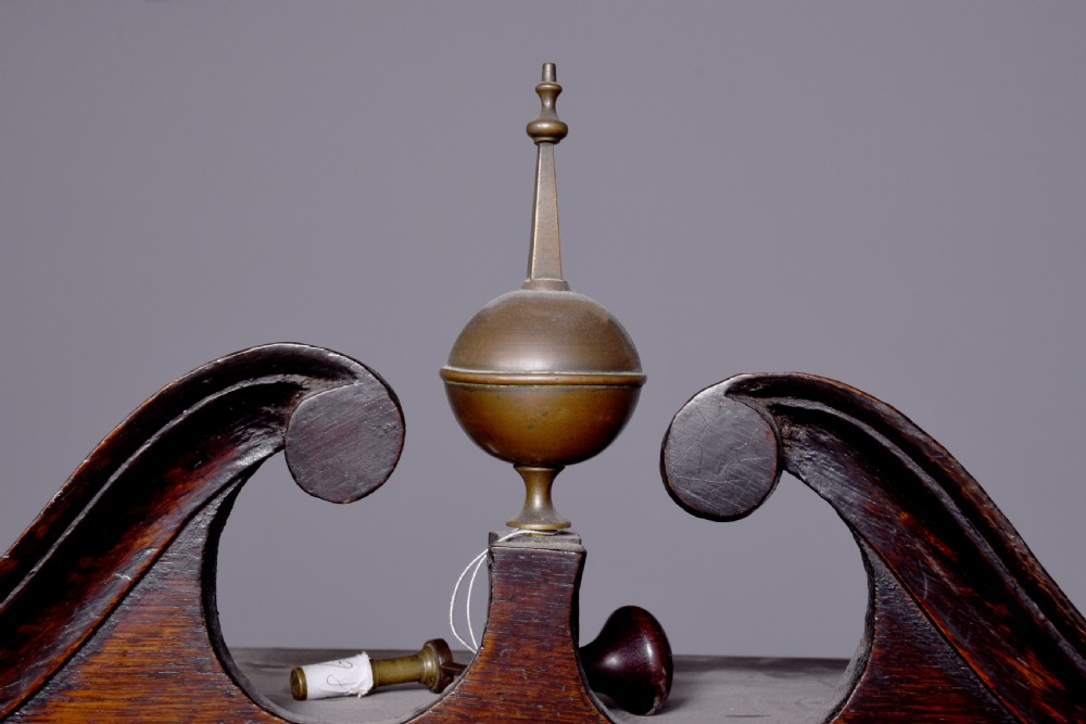 A George III dark mahogany longcase grandfather clock featuring a swan-neck pediment, brass finial, and an engraved brass arch dial. View IV