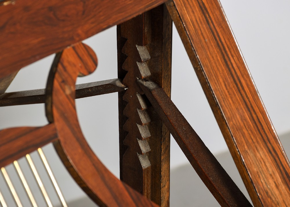 A George IV double-sided rosewood duet music stand featuring carved lyre frames mounted on a brass telescopic stem and a carved triform base. View IX