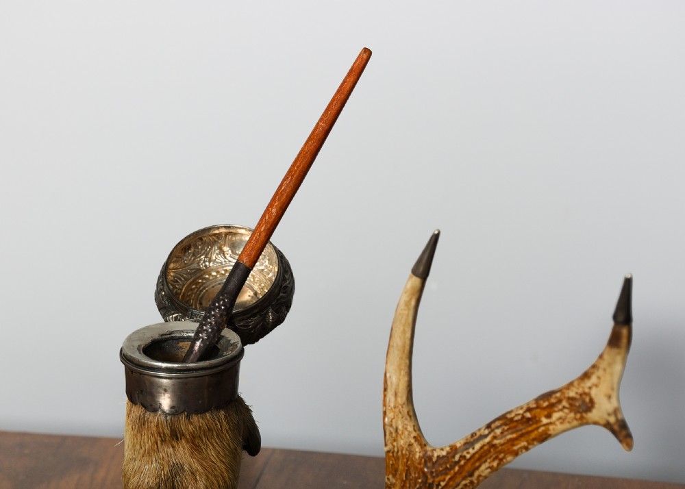 An antique Scottish carved oak desk stand featuring two upright stag antlers as pen rests and a central silver-mounted hoof inkwell. View III