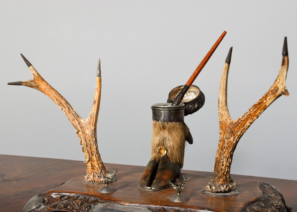 An antique Scottish carved oak desk stand featuring two upright stag antlers as pen rests and a central silver-mounted hoof inkwell. View IV