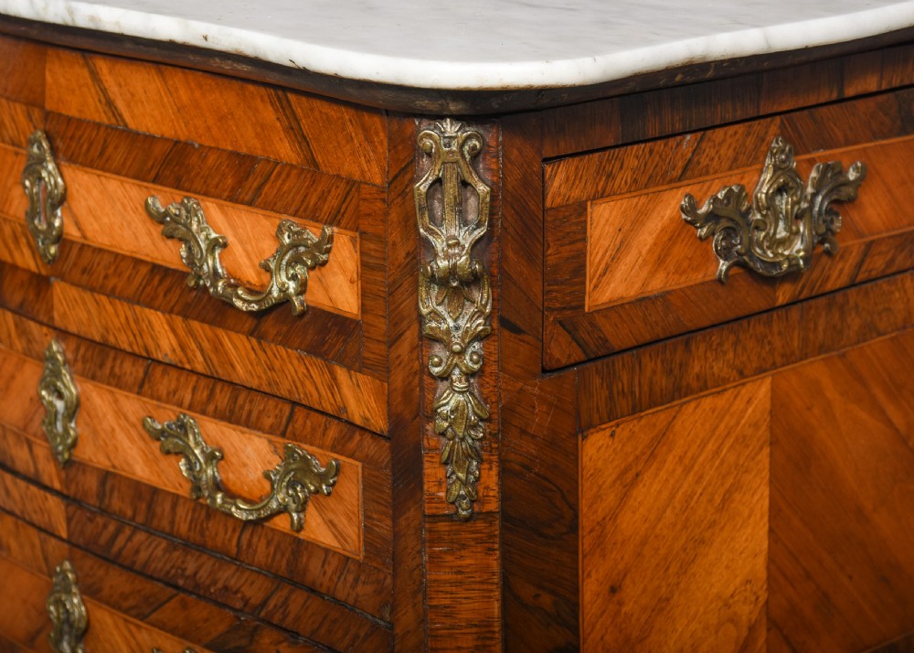 A French Louis XV style side table with a white marble top, three parquetry drawers, brass mounts, and slender cabriole legs. View V