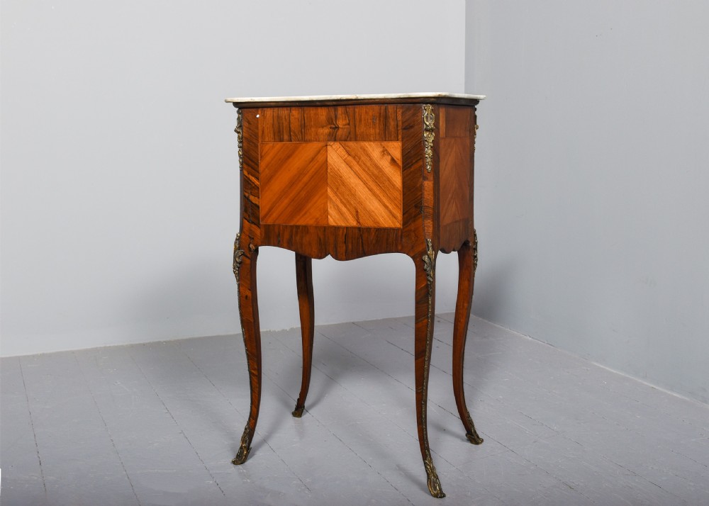 A French Louis XV style side table with a white marble top, three parquetry drawers, brass mounts, and slender cabriole legs. View X
