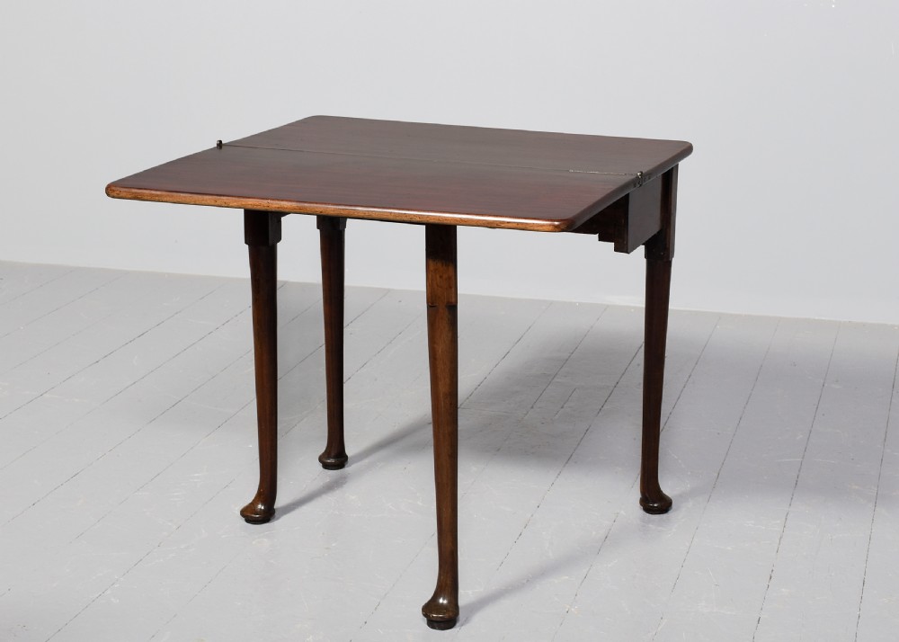 An 18th-century George II red walnut fold-over tea table with a single frieze drawer, brass brassware, shaped apron, and slender legs terminating in pad feet. View XI