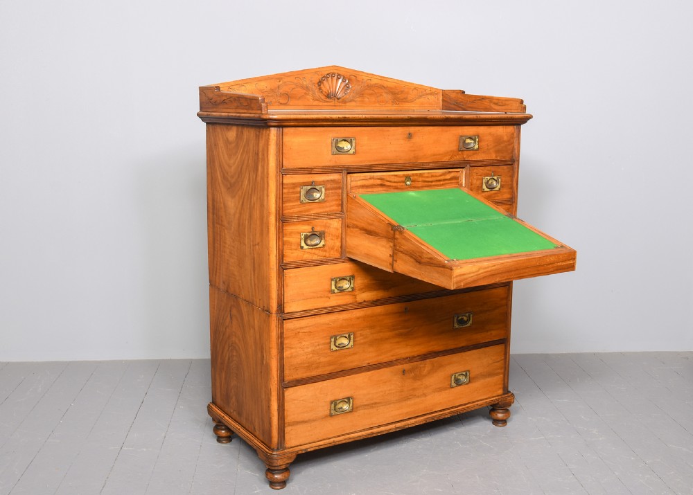 An antique two-part camphorwood military secretaire chest with recessed brass handles and a carved shell cresting. View III
