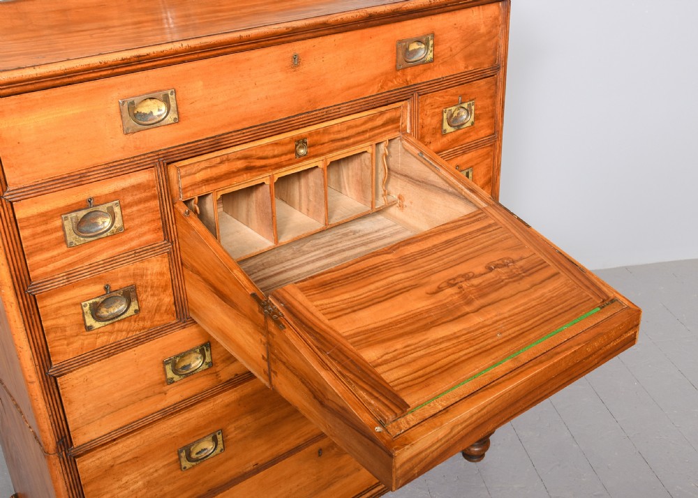 An antique two-part camphorwood military secretaire chest with recessed brass handles and a carved shell cresting. View IV