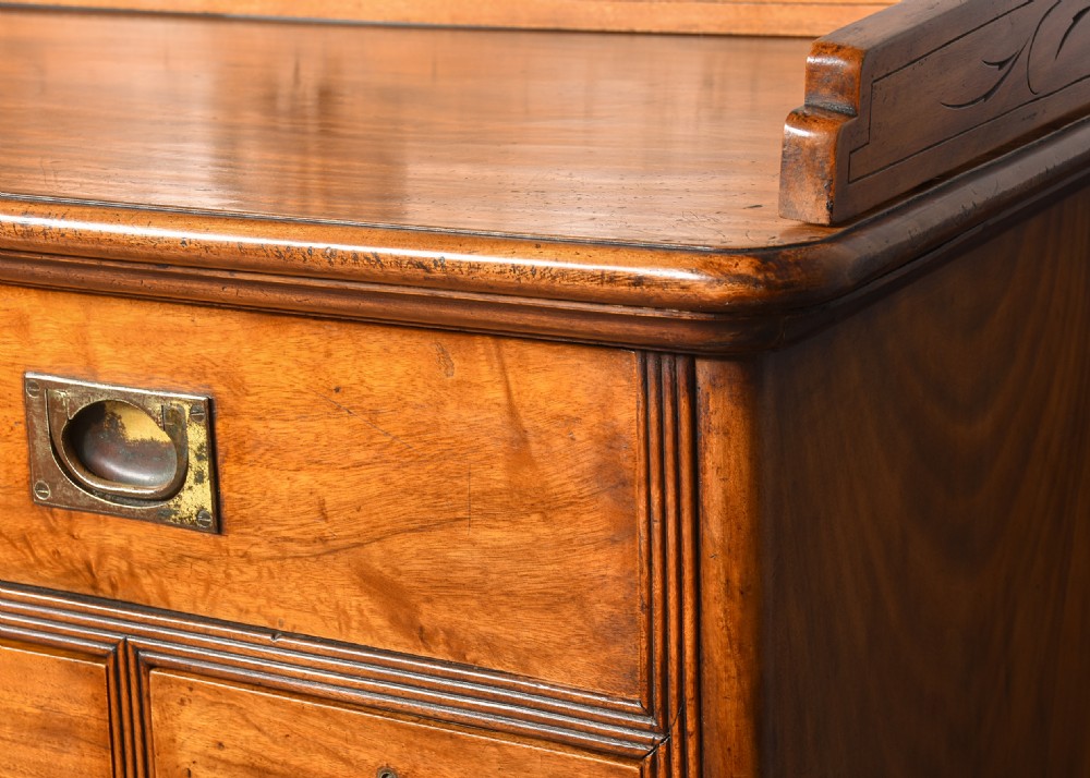 An antique two-part camphorwood military secretaire chest with recessed brass handles and a carved shell cresting. View IX