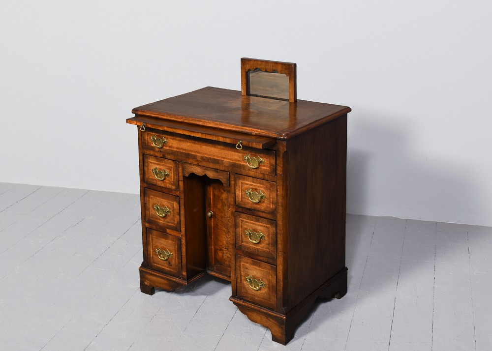 A George II style warm brown figured walnut kneehole dressing chest with brass drop handles, a pull-out slide, and a rectangular dressing mirror. View III