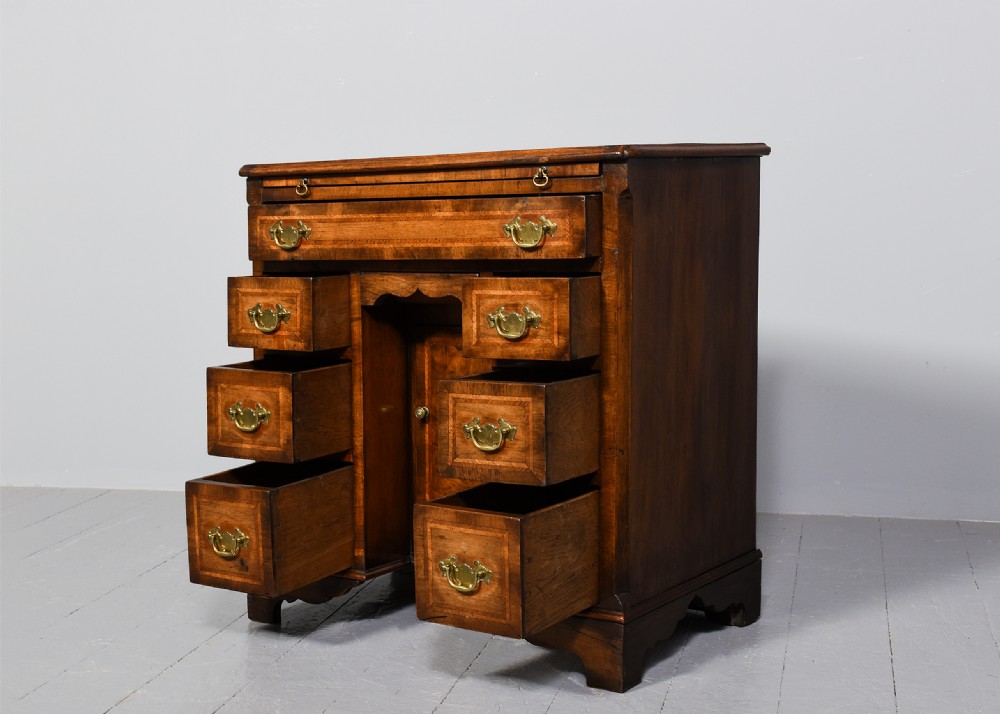 A George II style warm brown figured walnut kneehole dressing chest with brass drop handles, a pull-out slide, and a rectangular dressing mirror. View VIII