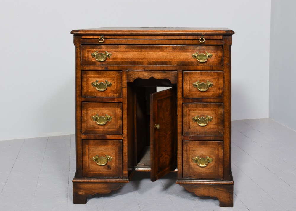 A George II style warm brown figured walnut kneehole dressing chest with brass drop handles, a pull-out slide, and a rectangular dressing mirror. View IX