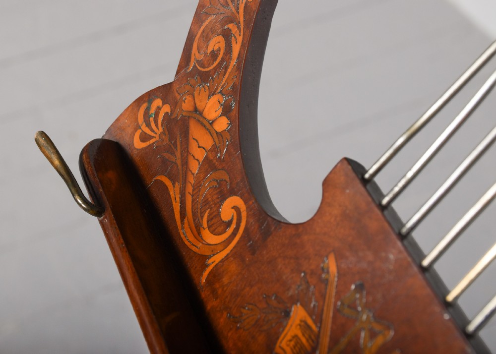 A mahogany music stand featuring a lyre-shaped top rest with floral inlay, an adjustable brass rod, turned column, and a tripod base. View III