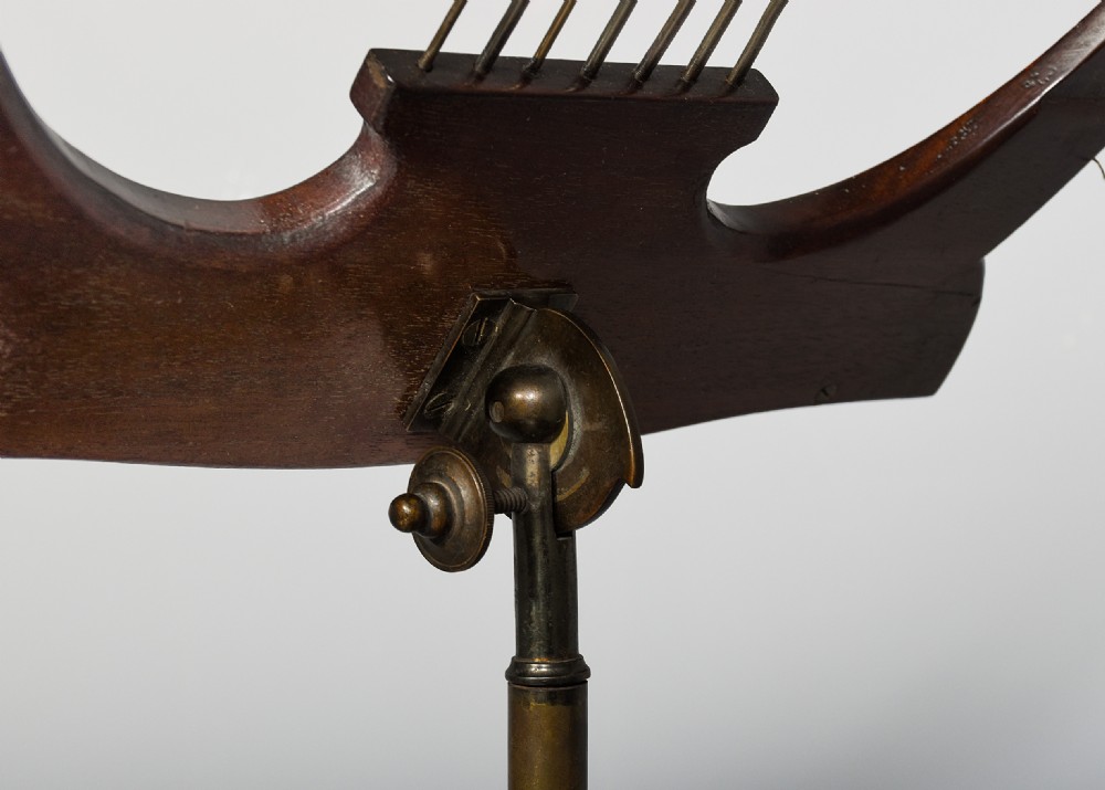 A mahogany music stand featuring a lyre-shaped top rest with floral inlay, an adjustable brass rod, turned column, and a tripod base. View VII