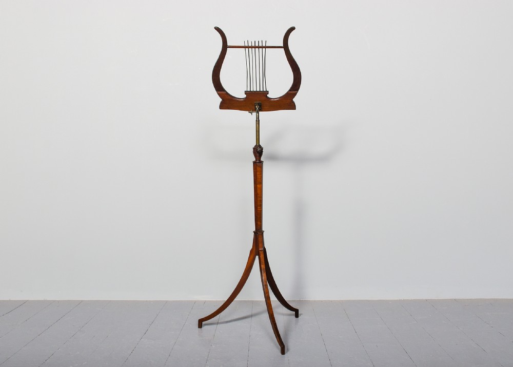 A mahogany music stand featuring a lyre-shaped top rest with floral inlay, an adjustable brass rod, turned column, and a tripod base. View VIII