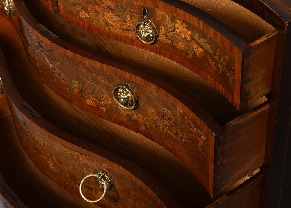 A George III style serpentine front chest of drawers featuring satinwood and floral marquetry inlay with brass ring handles. View VII