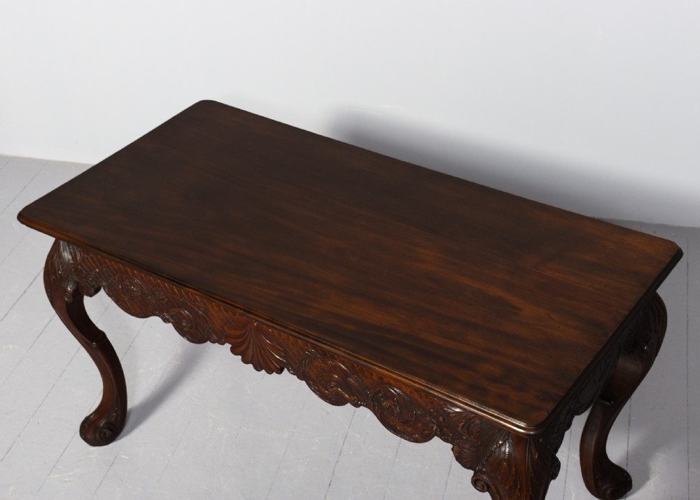 A dark carved mahogany console table in the Irish Chippendale style, featuring a deeply scalloped apron with central shell carving and cabriole legs. View VI