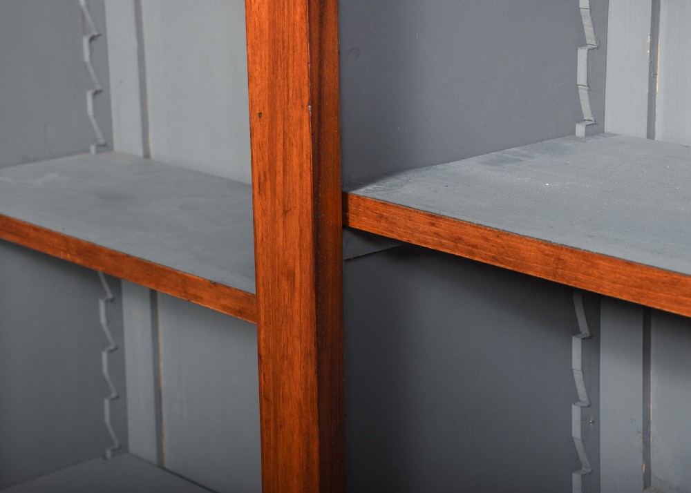 A large Victorian mahogany breakfront open bookcase featuring three sectioned compartments with adjustable shelves and a grey painted interior background. View V