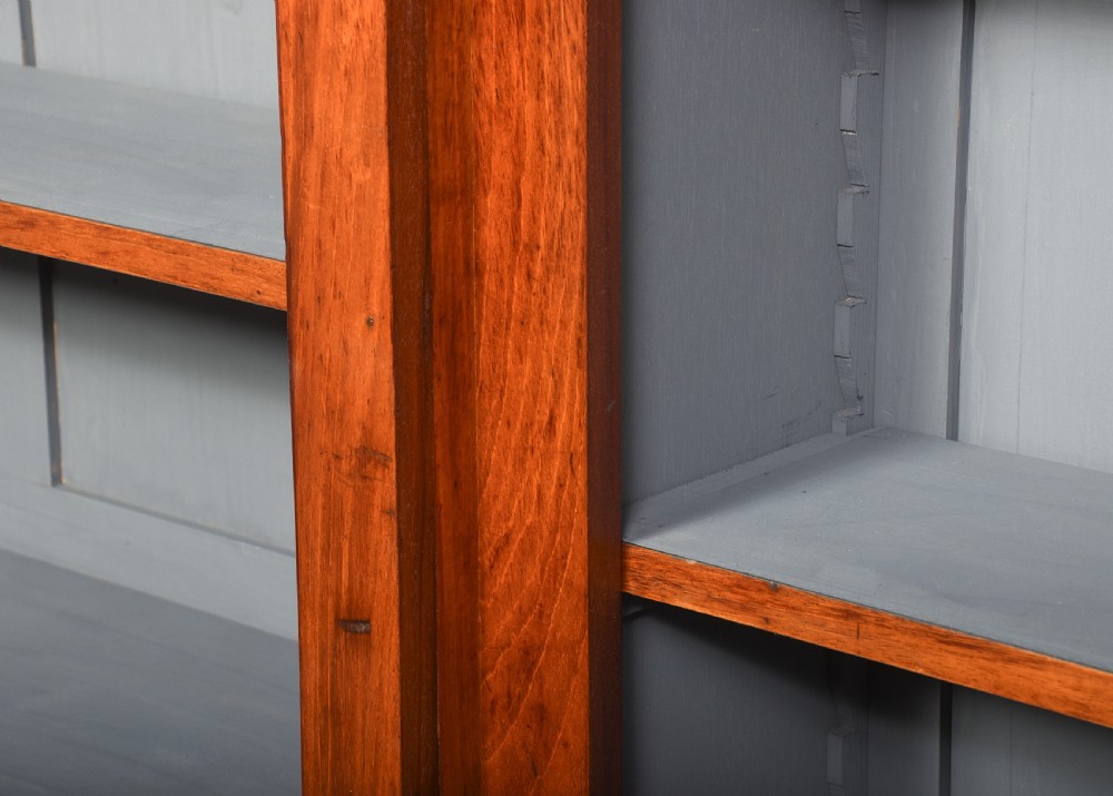 A large Victorian mahogany breakfront open bookcase featuring three sectioned compartments with adjustable shelves and a grey painted interior background. View VI