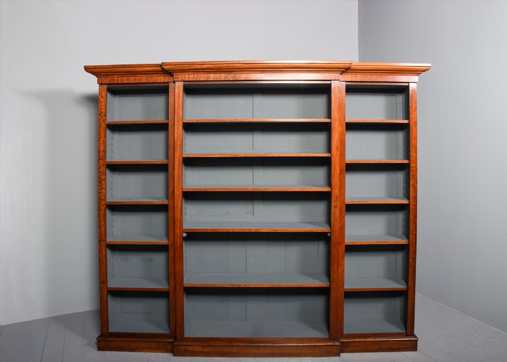 A large Victorian mahogany breakfront open bookcase featuring three sectioned compartments with adjustable shelves and a grey painted interior background. View VIII
