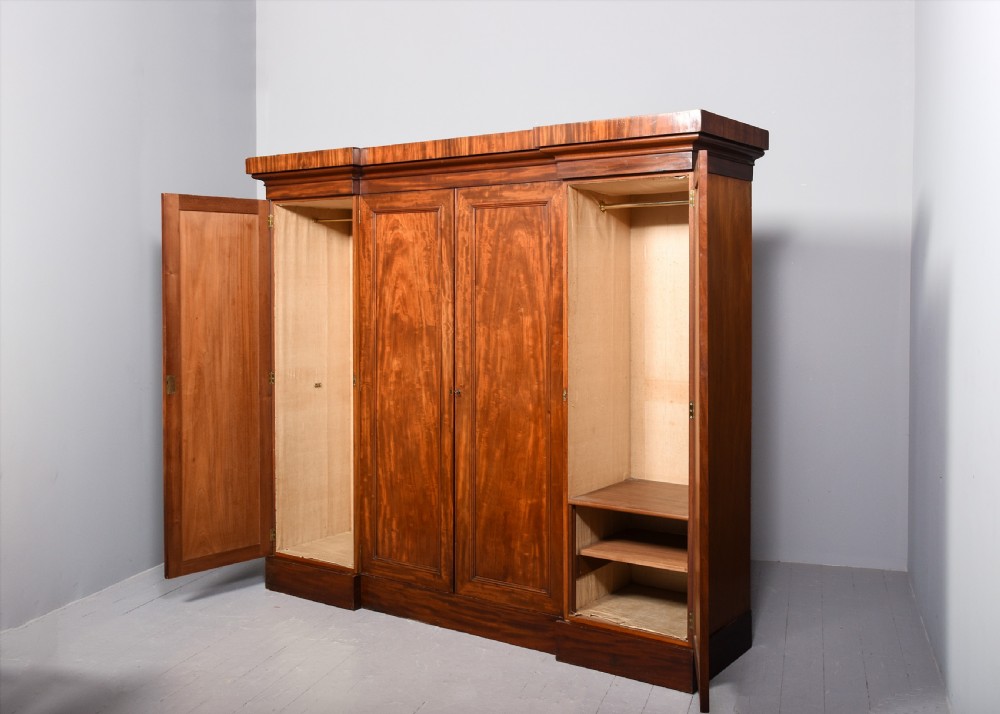 A George IV flame mahogany four-door wardrobe with a breakfront profile and moulded cornice. View III