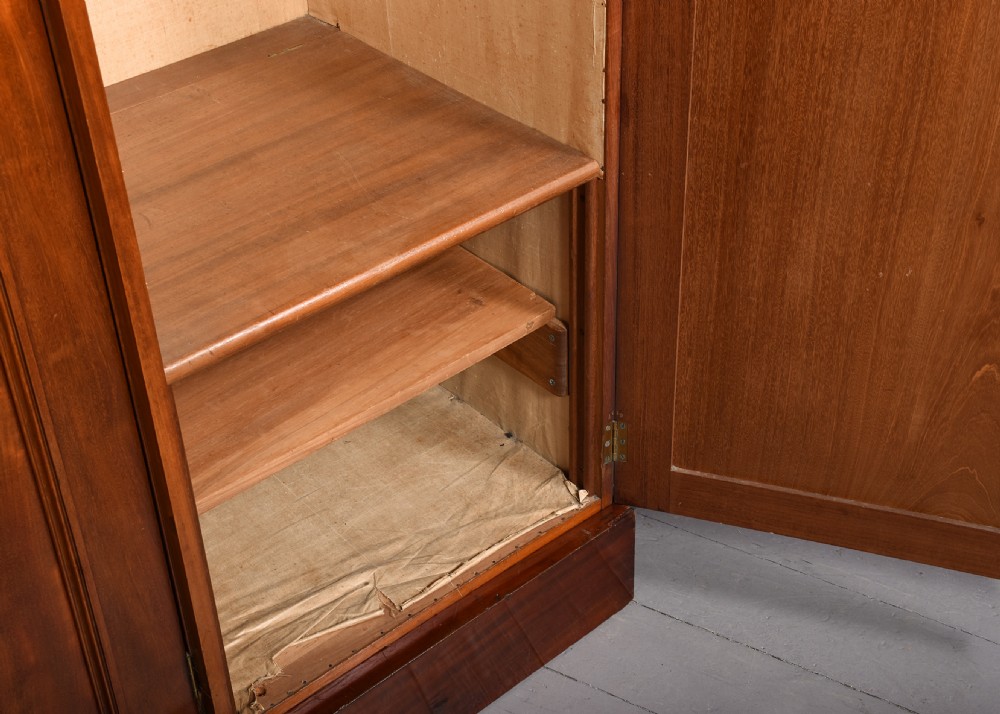 A George IV flame mahogany four-door wardrobe with a breakfront profile and moulded cornice. View V