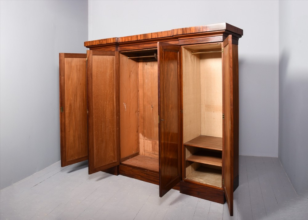 A George IV flame mahogany four-door wardrobe with a breakfront profile and moulded cornice. View VI