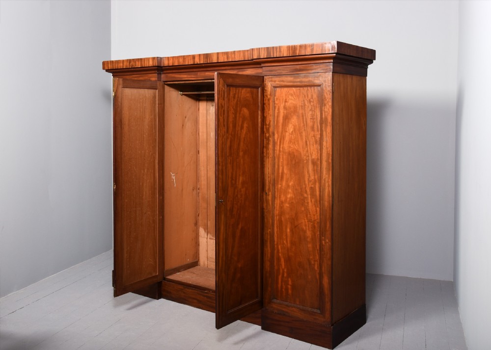 A George IV flame mahogany four-door wardrobe with a breakfront profile and moulded cornice. View VIII