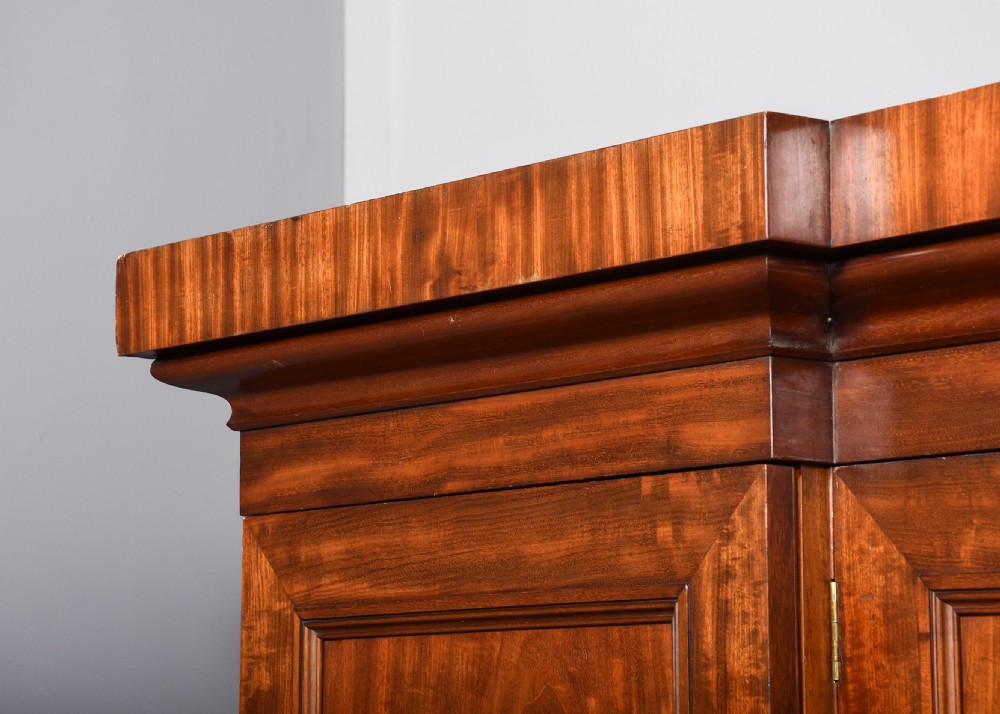 A George IV flame mahogany four-door wardrobe with a breakfront profile and moulded cornice. View XI