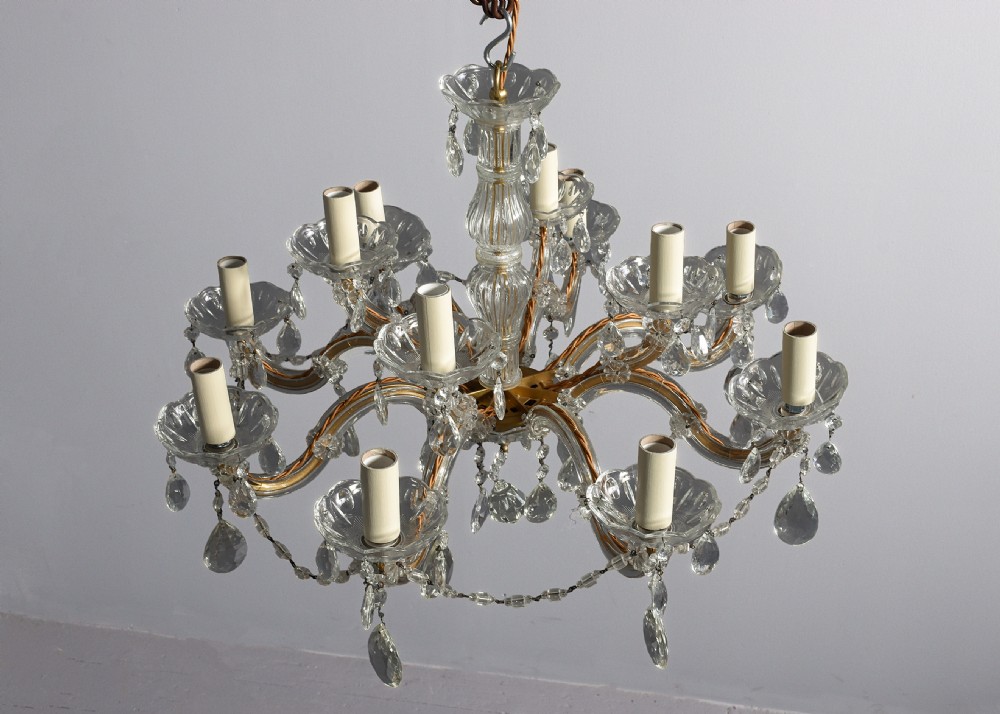 A multi-arm clear glass and cut crystal chandelier featuring hanging teardrop prisms, scalloped glass candle cups, and white candle sleeves. View VIII