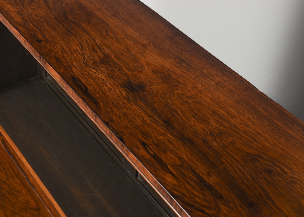 A two-part Regency rosewood bookcase featuring an open upper shelf area above a twin-door lower cupboard with carved corbels. View IV