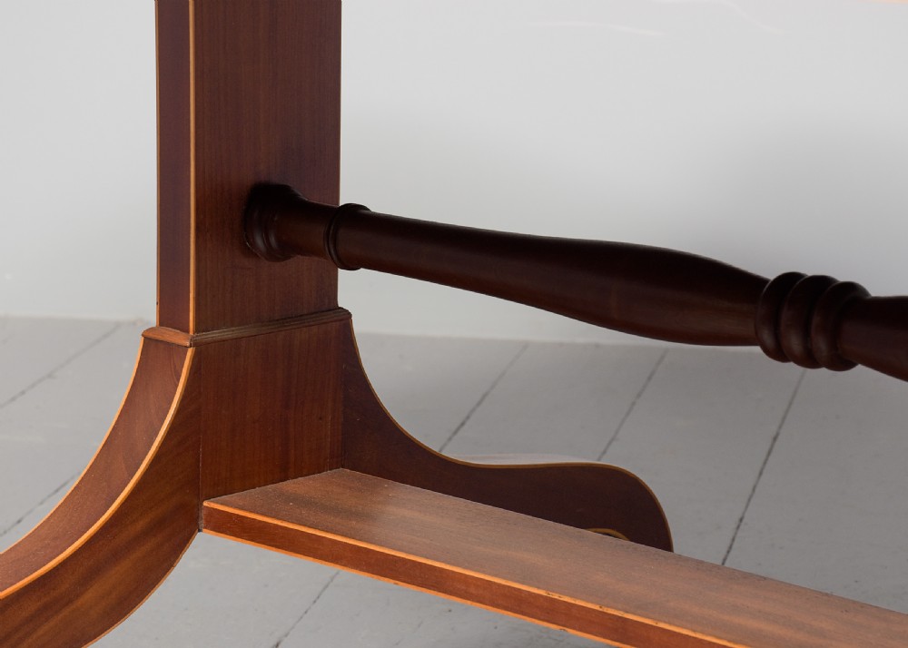 A Regency mahogany sofa table featuring drop flaps, geometric string inlay, twin frieze drawers, and splayed legs with brass castors. View VIII