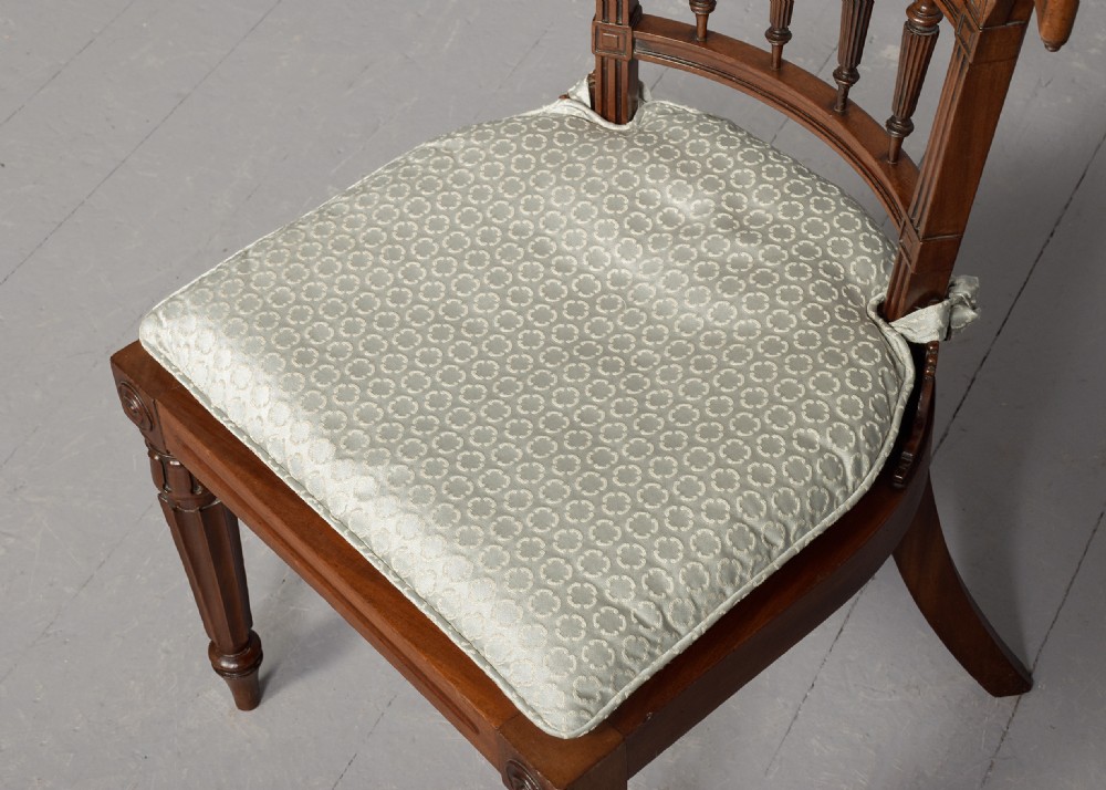 A carved mahogany side chair featuring a wide curved crest rail, pierced fretwork back, cushioned cane seat, and reeded front legs. View III