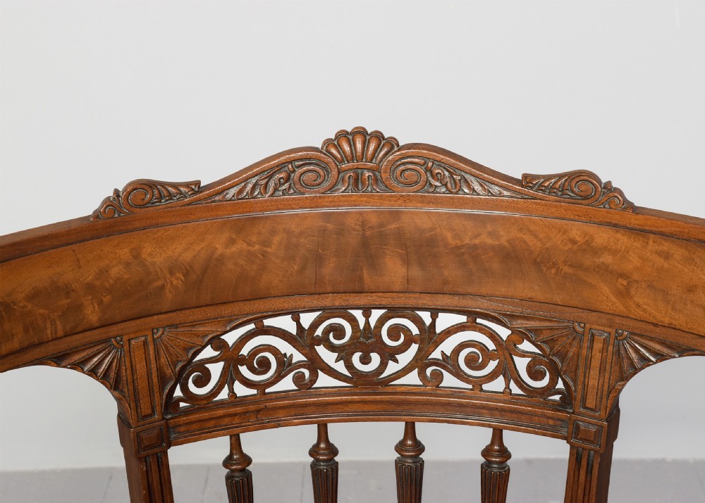 A carved mahogany side chair featuring a wide curved crest rail, pierced fretwork back, cushioned cane seat, and reeded front legs. View IV