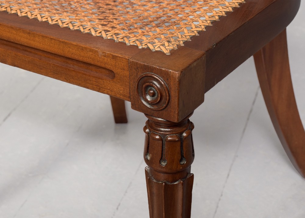 A carved mahogany side chair featuring a wide curved crest rail, pierced fretwork back, cushioned cane seat, and reeded front legs. View VI