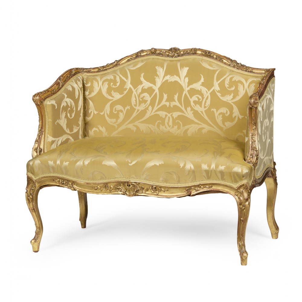 A French Louis XV style giltwood canape featuring carved floral motifs, cabriole legs, and gold floral damask upholstery.
