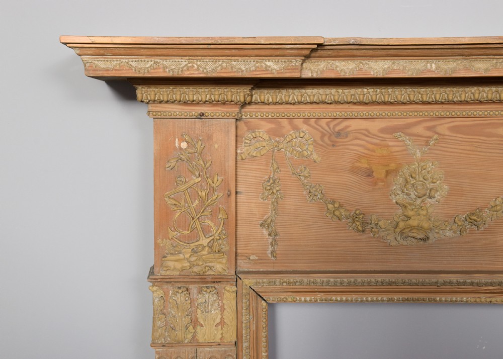 A George III carved pine and gesso mantelpiece featuring fluted pilasters, classical swags, and a central floral garland motif. View V
