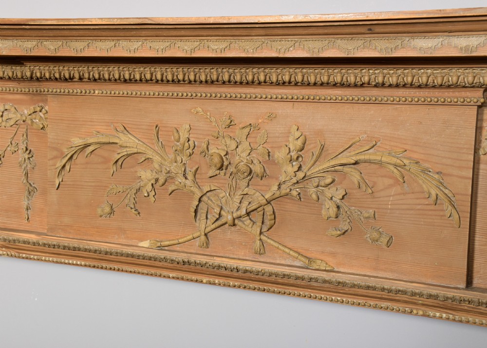 A George III carved pine and gesso mantelpiece featuring fluted pilasters, classical swags, and a central floral garland motif. View VI