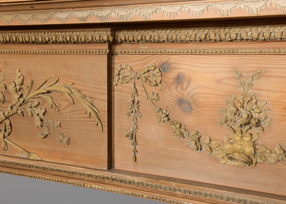 A George III carved pine and gesso mantelpiece featuring fluted pilasters, classical swags, and a central floral garland motif. View VII