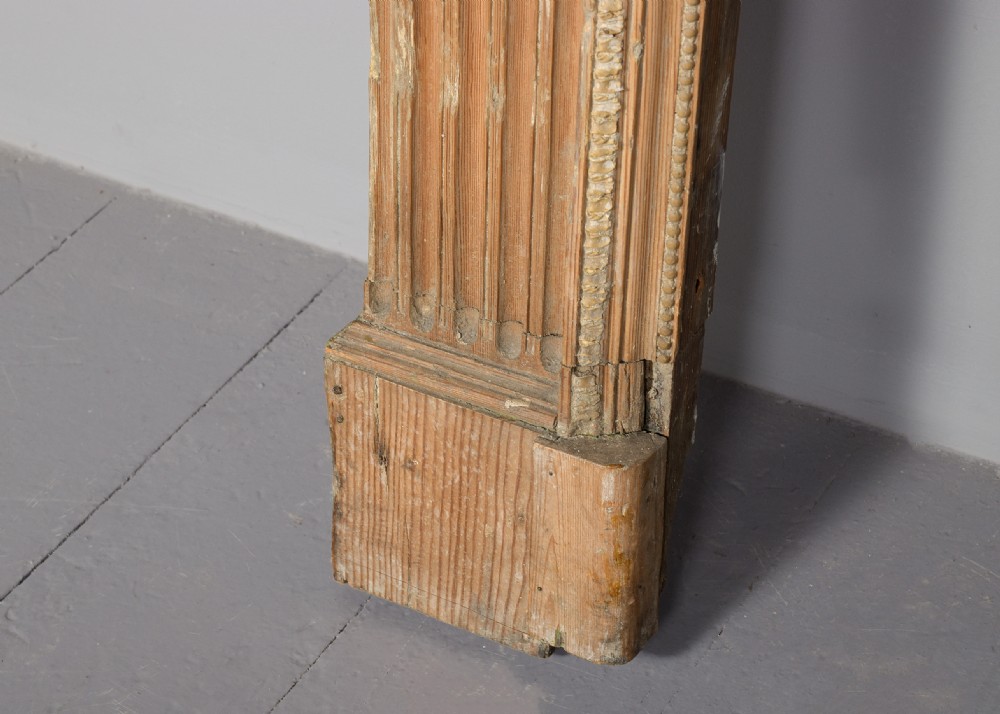 A George III carved pine and gesso mantelpiece featuring fluted pilasters, classical swags, and a central floral garland motif. View VIII