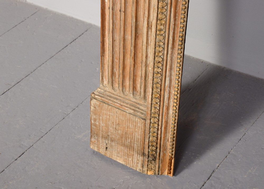 A George III carved pine and gesso fireplace surround featuring fluted jambs, classical urn motifs, and a detailed frieze. View V