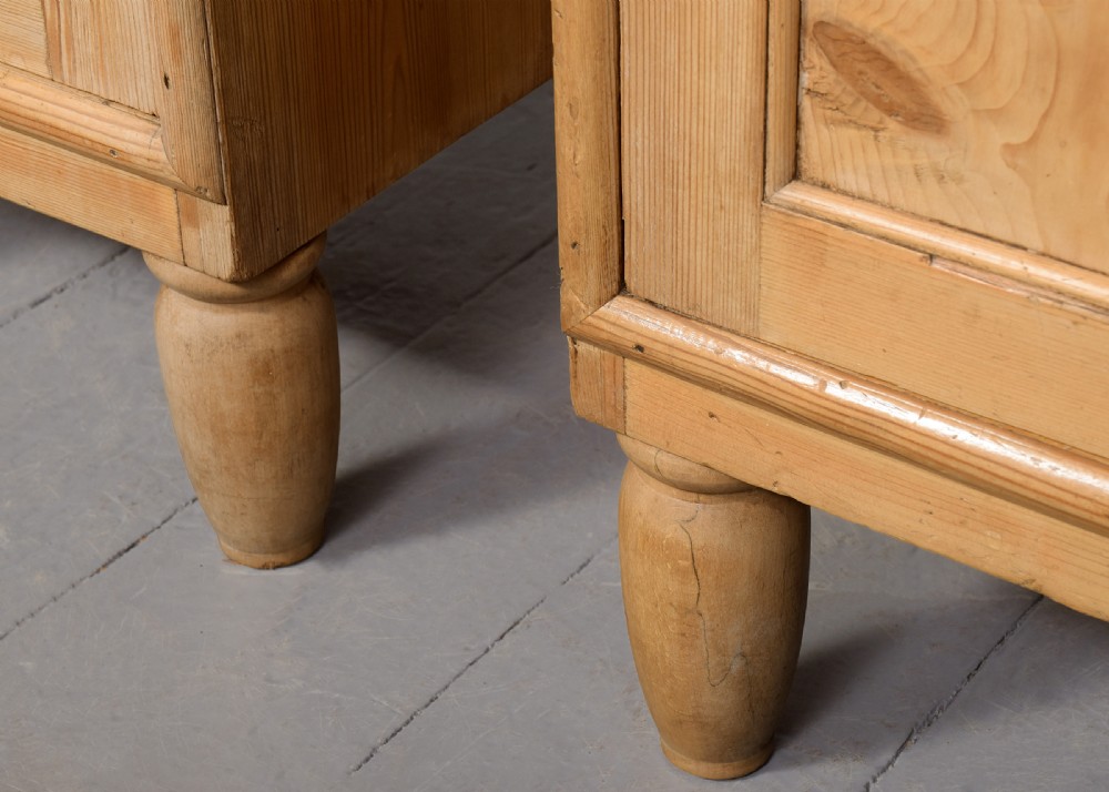 A pair of natural pine bedside cabinets with grey marble tops, single drawers, and diamond carved door panels on turned feet. View II
