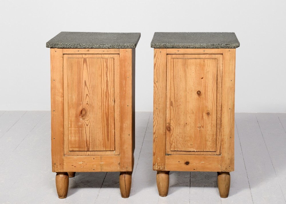 A pair of natural pine bedside cabinets with grey marble tops, single drawers, and diamond carved door panels on turned feet. View V