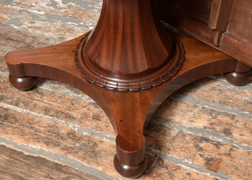 A William IV twin-pedestal dining table crafted from dark figured mahogany with rounded corners and plinth bases on bun feet. View VIII