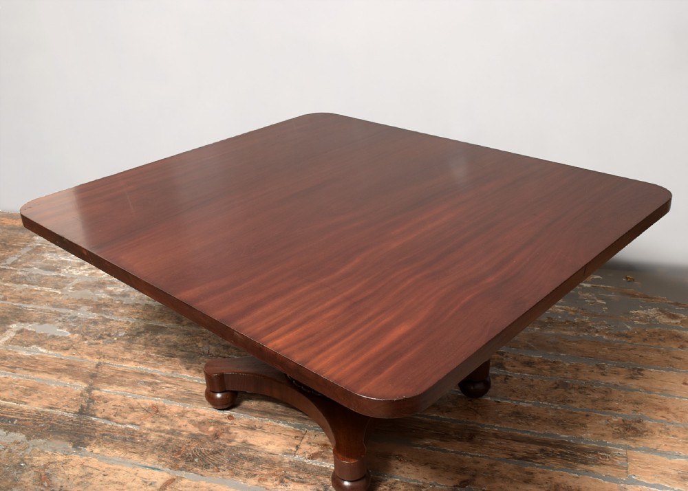 A William IV twin-pedestal dining table crafted from dark figured mahogany with rounded corners and plinth bases on bun feet. View X
