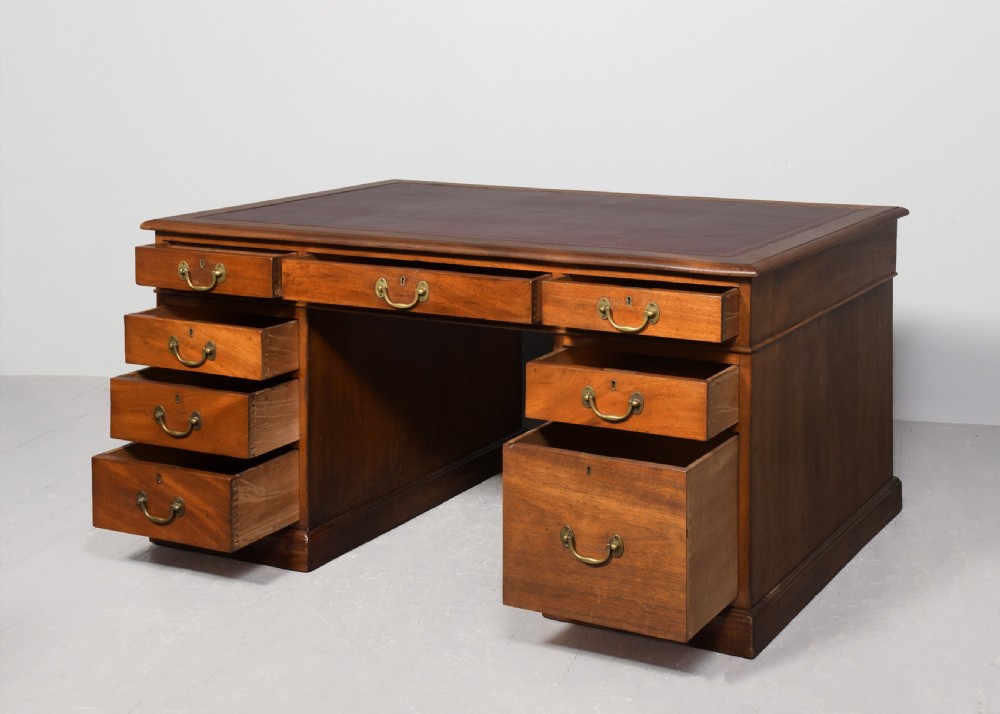 A large Victorian mahogany partners desk with a brown leather inset writing surface, twin pedestals with drawers, and brass swan-neck drop handles. View II